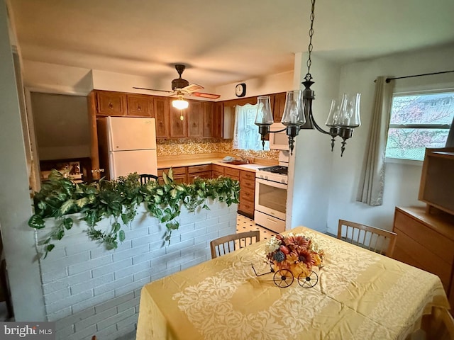 1109 San Jose Dr, Glendora, NJ 08029 - kitchen featuring decorative backsplash, ceiling fan, brown cabinetry, a sink, and white appliances