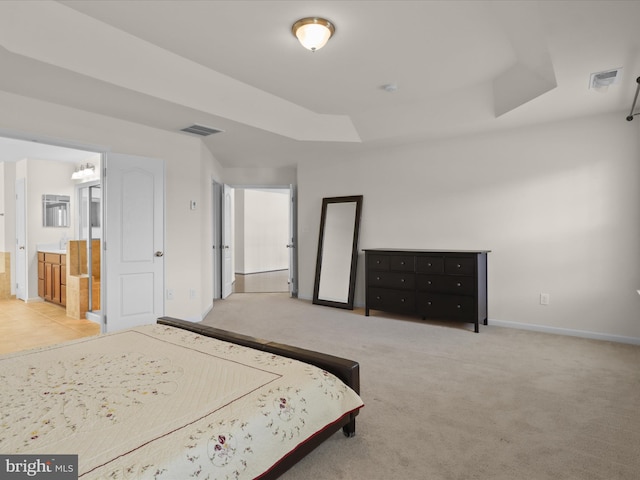 bedroom featuring a tray ceiling, carpet, visible vents, and baseboards