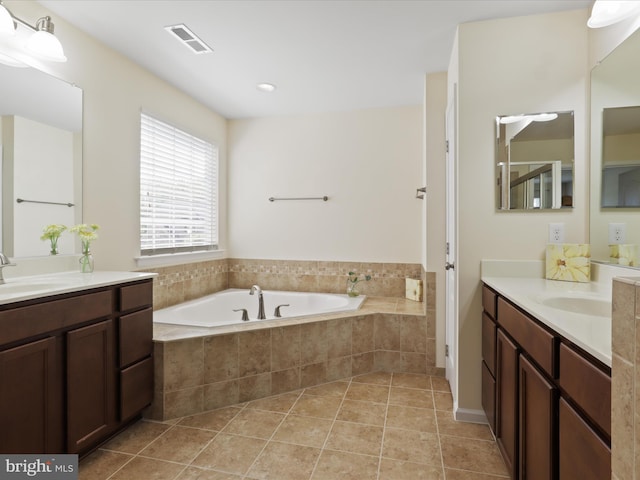 bathroom with visible vents, a sink, tile patterned flooring, a garden tub, and two vanities