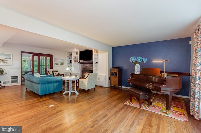 4401 Aragon Pl, Alexandria, VA 22309 - living room featuring wood finished floors, a brick fireplace, baseboards, and an accent wall