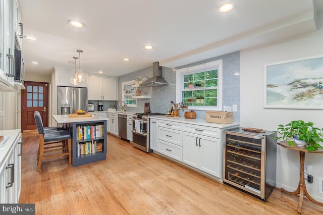 4401 Aragon Pl, Alexandria, VA 22309 - kitchen featuring appliances with stainless steel finishes, wine cooler, wall chimney exhaust hood, white cabinetry, and light countertops