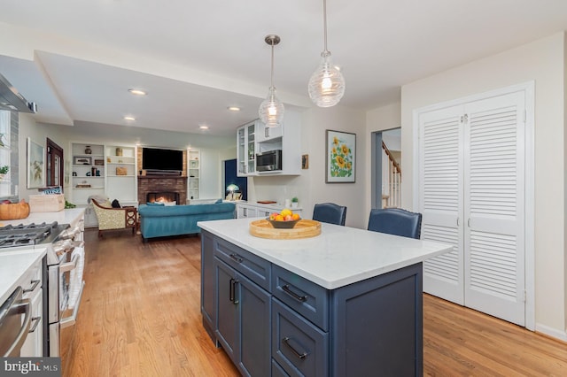 4401 Aragon Pl, Alexandria, VA 22309 - kitchen with stainless steel appliances, light wood finished floors, light countertops, a fireplace, and recessed lighting