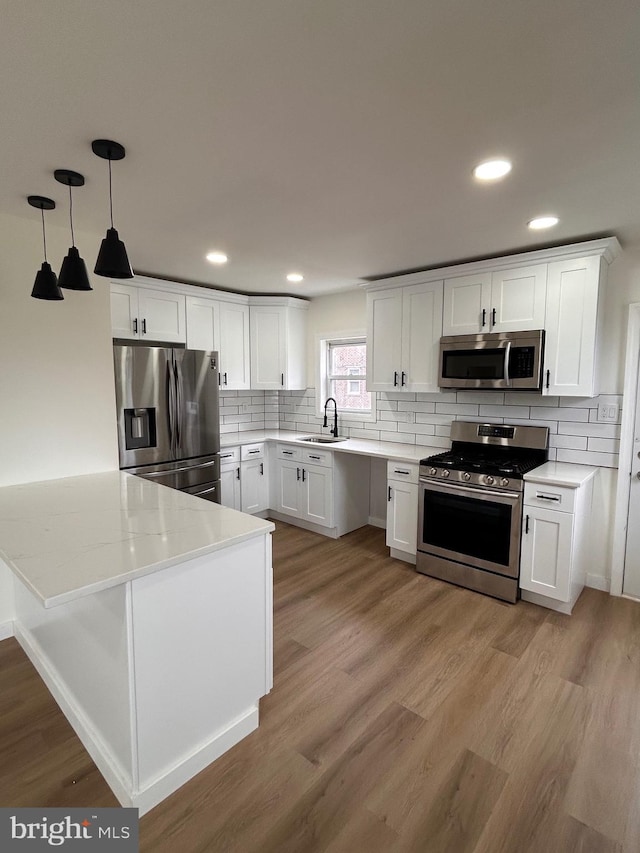 kitchen featuring a sink, white cabinetry, backsplash, and appliances with stainless steel finishes