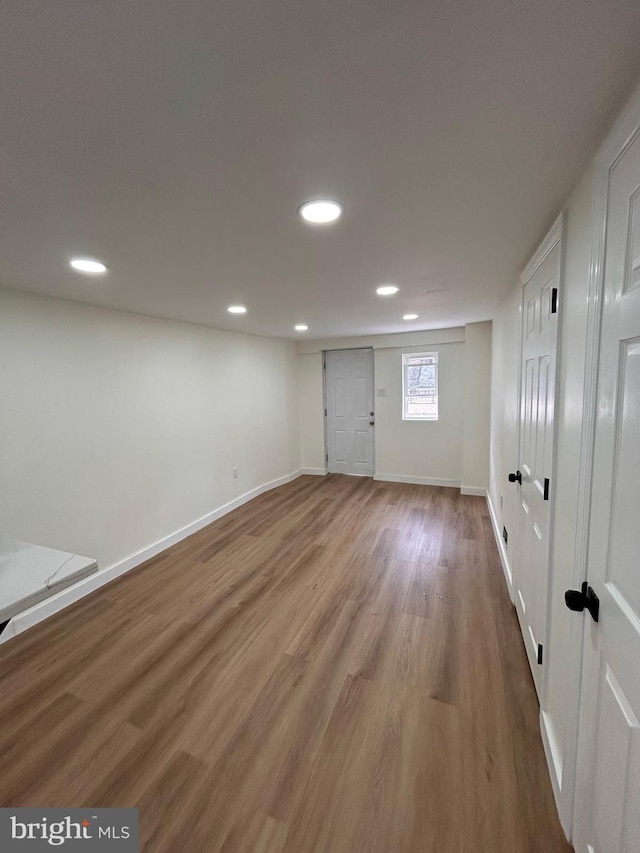 basement with baseboards, recessed lighting, and wood finished floors