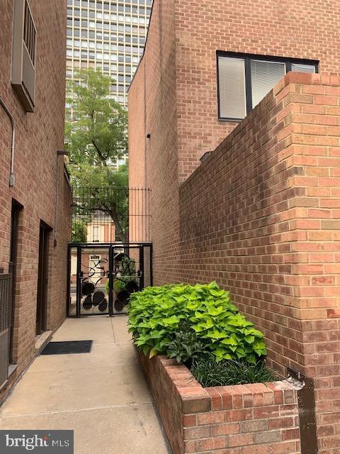 view of property exterior featuring a gate and brick siding