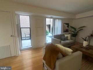 living room featuring light wood finished floors and visible vents