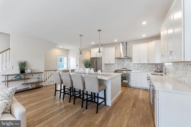 135 Walnut Ave, North Wildwood, NJ 08260 - kitchen with decorative backsplash, high end appliances, wall chimney exhaust hood, white cabinets, and a sink
