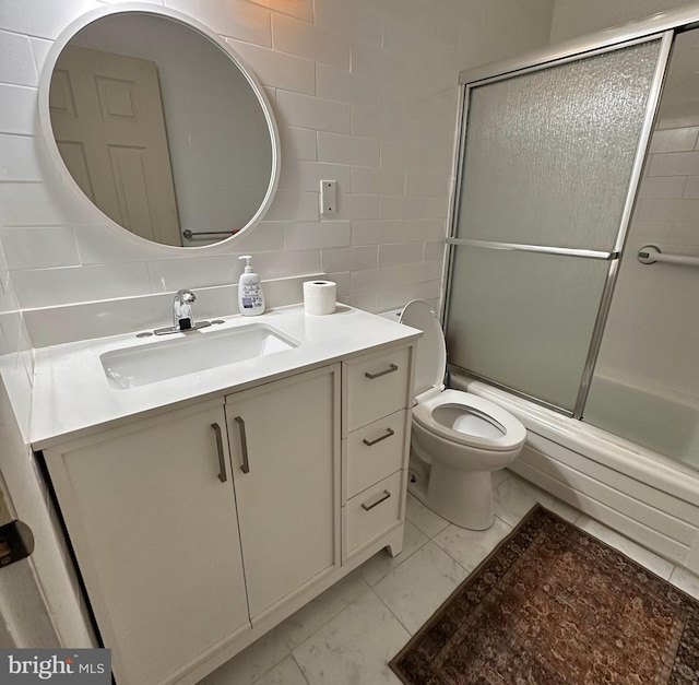 395 Hickory Ave, Carneys Point, NJ 08069 - full bathroom featuring marble look tiles, vanity, toilet, tile walls, and shower / bath combination with glass door