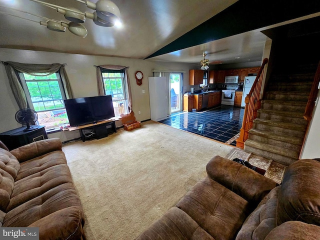 living room with lofted ceiling, stairs, baseboards, and dark carpet