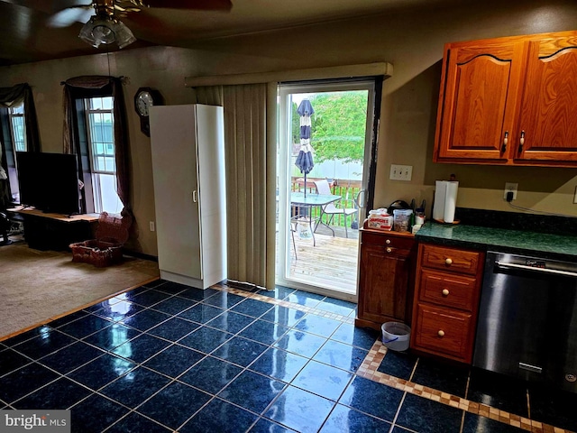 kitchen featuring dishwashing machine, dark tile patterned floors, a ceiling fan, dark countertops, and baseboards