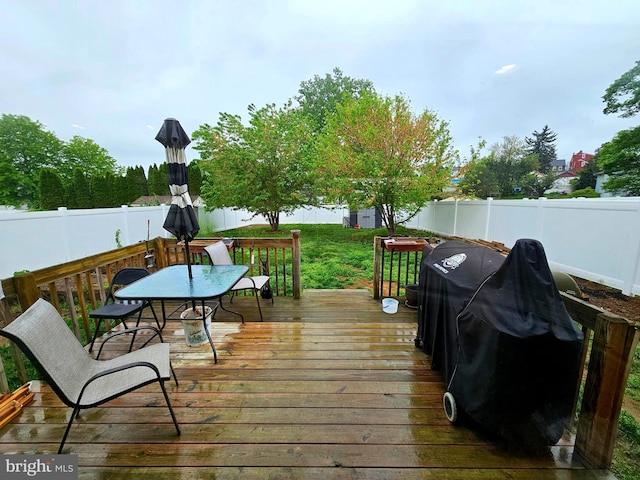 wooden deck featuring outdoor dining space and a fenced backyard