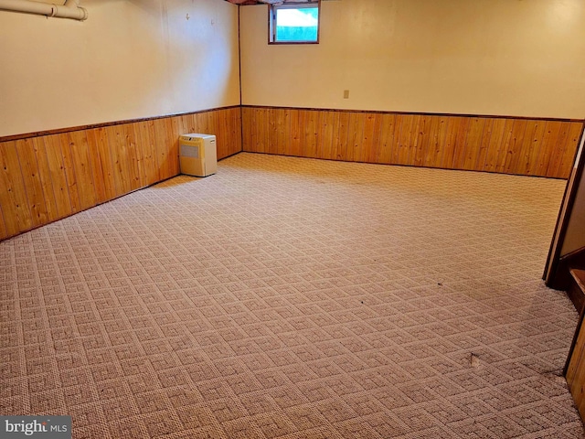 basement with carpet flooring, wooden walls, and wainscoting