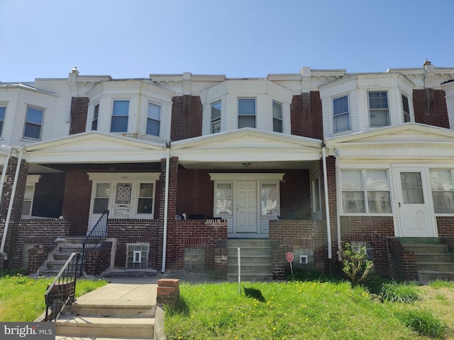 view of front facade featuring covered porch and brick siding