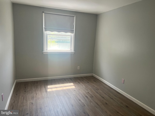 unfurnished room with baseboards and wood finished floors