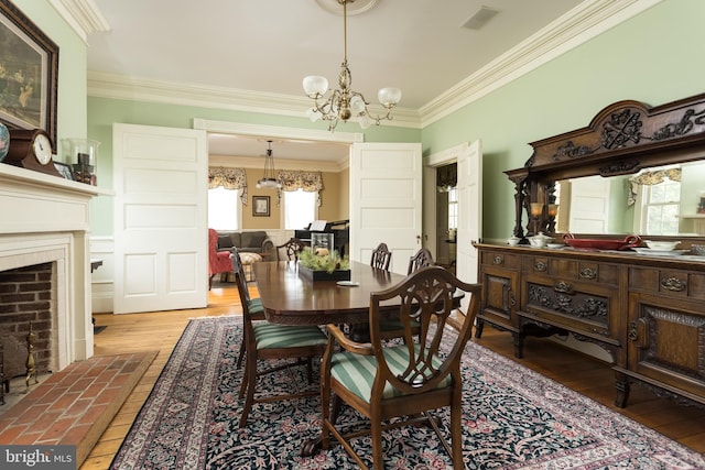 3401 Old Level Rd, Havre De Grace, MD 21078 - dining area featuring healthy amount of natural light, a chandelier, ornamental molding, a brick fireplace, and wood-type flooring