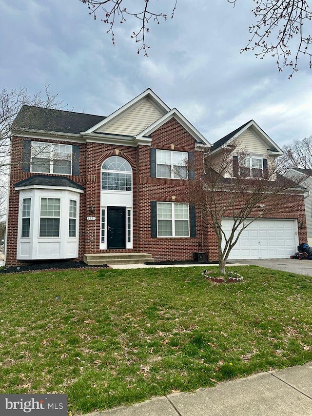 view of front of home with an attached garage, a front lawn, and brick siding