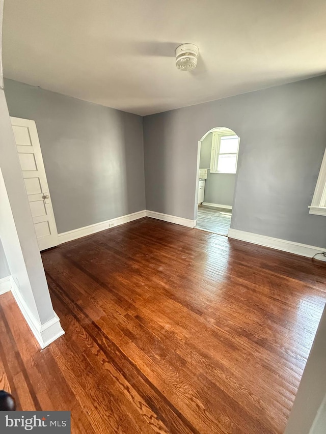 7124 Seaford Rd, Upper Darby, PA 19082 - spare room featuring arched walkways, baseboards, and wood finished floors