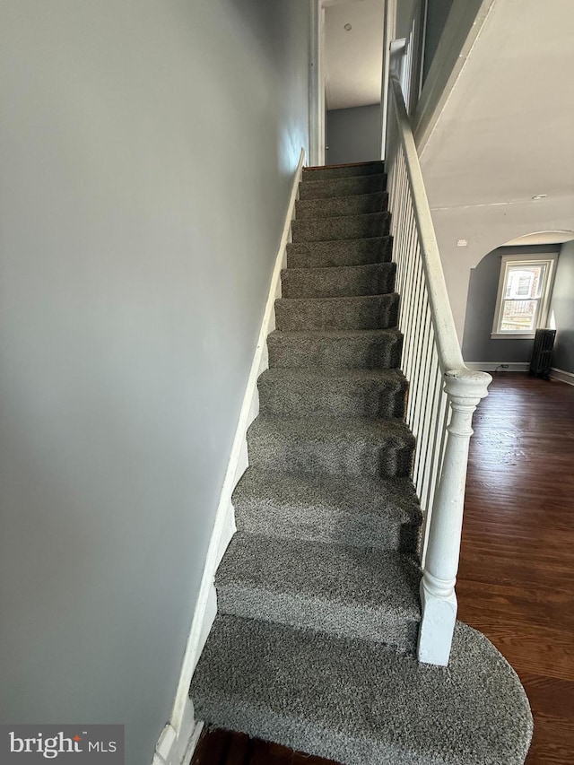 7124 Seaford Rd, Upper Darby, PA 19082 - stairs with arched walkways, baseboards, and wood finished floors
