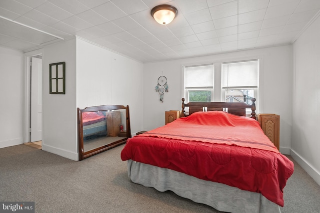 carpeted bedroom with crown molding and baseboards