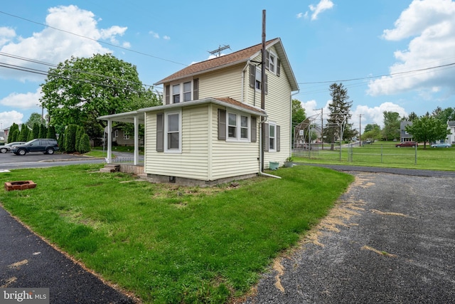 view of home's exterior featuring fence and a lawn