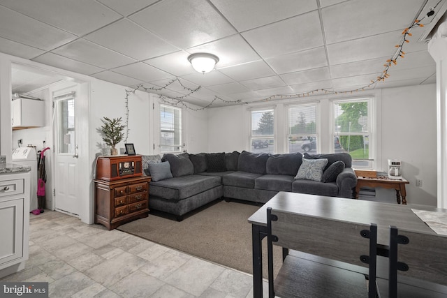 living room featuring a paneled ceiling and washer / clothes dryer