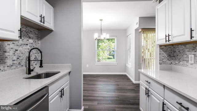 kitchen featuring backsplash, stainless steel dishwasher, a sink, baseboards, and white cabinets