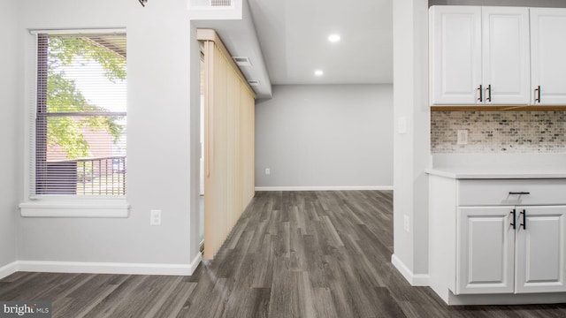 interior space featuring white cabinets, recessed lighting, baseboards, tasteful backsplash, and dark wood-type flooring