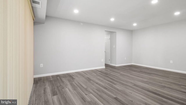 empty room featuring dark wood finished floors, baseboards, recessed lighting, and visible vents