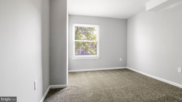 unfurnished room with carpet floors and baseboards