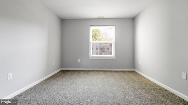 carpeted spare room with visible vents and baseboards