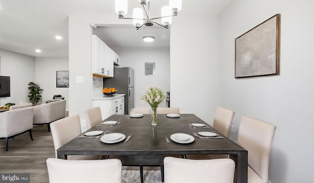 dining space with recessed lighting, an inviting chandelier, and wood finished floors