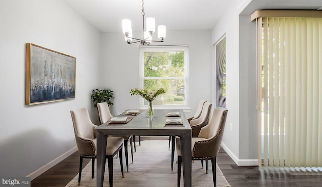 dining area with baseboards, dark wood finished floors, and a chandelier