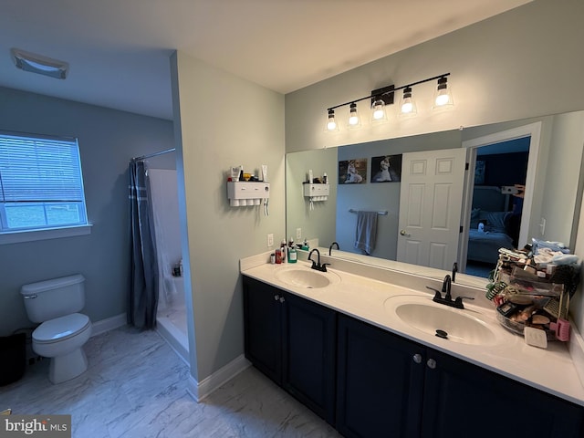 ensuite bathroom featuring a sink, a stall shower, toilet, and marble finish floor