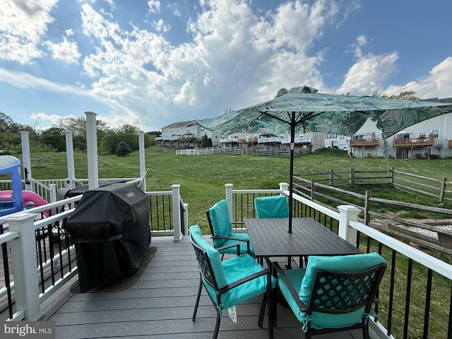 wooden terrace with outdoor dining area, fence, a yard, and area for grilling
