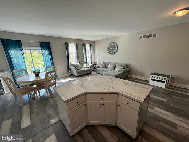 living room featuring baseboards, dark wood finished floors, and visible vents