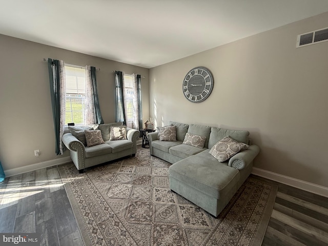 living area featuring baseboards, wood finished floors, and visible vents