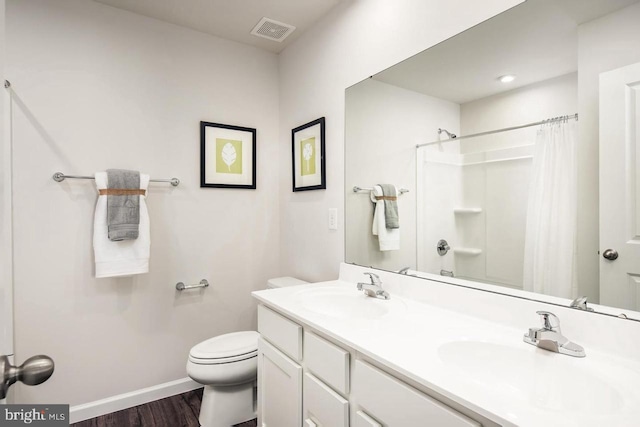 full bathroom with toilet, baseboards, visible vents, and a sink