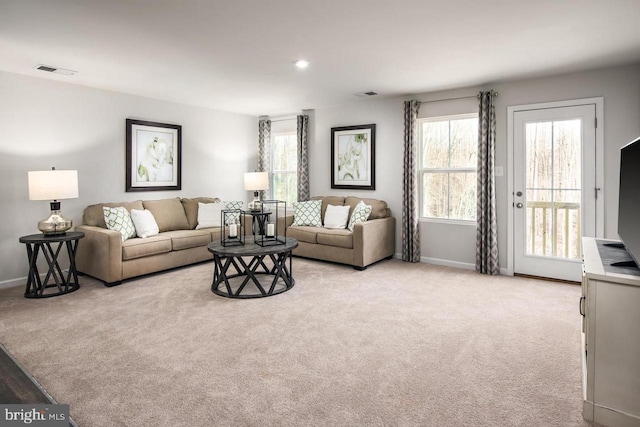 living area featuring baseboards, light colored carpet, and visible vents