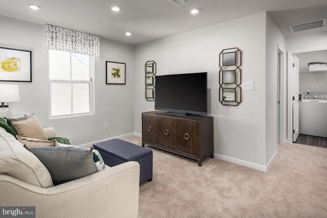 living area featuring light carpet, washer / clothes dryer, recessed lighting, baseboards, and visible vents