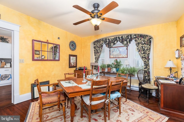 dining room featuring a ceiling fan, baseboards, wood finished floors, and a baseboard radiator