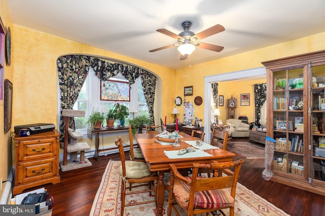 dining area featuring a ceiling fan, wood finished floors, and baseboard heating