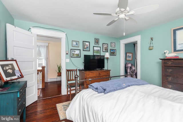 bedroom with ceiling fan, a baseboard radiator, and wood finished floors