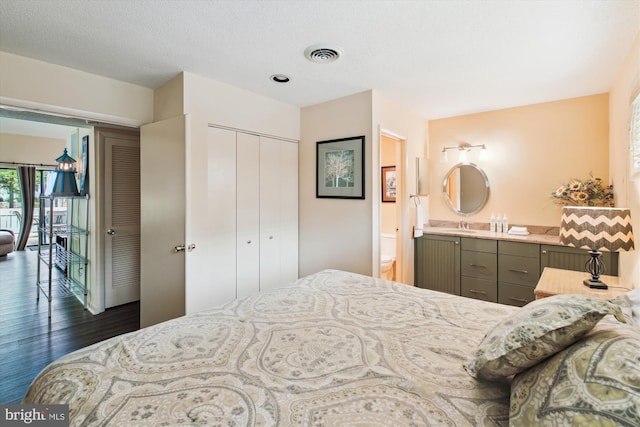39234 Timberlake Ct Unit 9203, Bethany Beach, DE 19930 - bedroom featuring a sink, a closet, ensuite bath, visible vents, and dark wood-style flooring