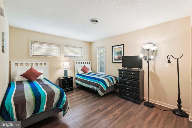 39234 Timberlake Ct Unit 9203, Bethany Beach, DE 19930 - bedroom featuring dark wood-style flooring, a textured ceiling, baseboards, and visible vents