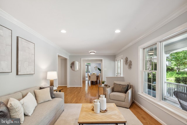 living room with plenty of natural light, light wood-style flooring, ornamental molding, recessed lighting, and baseboards
