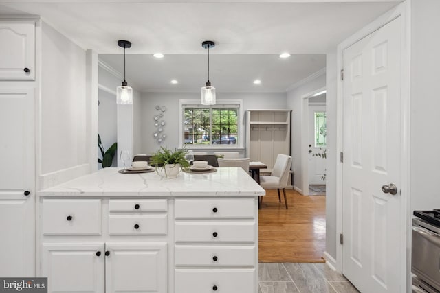 kitchen with crown molding, white cabinetry, light stone counters, hanging light fixtures, and recessed lighting