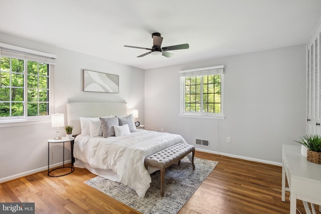 bedroom with wood finished floors, baseboards, and a ceiling fan