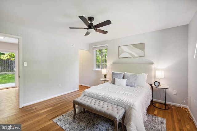 bedroom with baseboards, wood finished floors, and ceiling fan