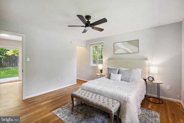 bedroom with baseboards, wood finished floors, and ceiling fan