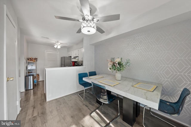 dining room with a ceiling fan and wood finished floors